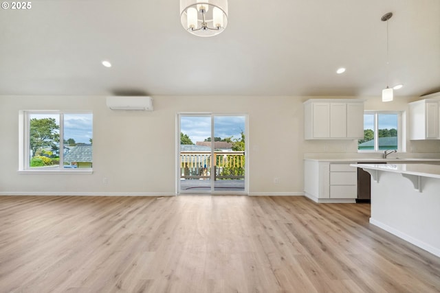 655 11th St SW, Bandon, OR 97411 - unfurnished living room with a wall mounted air conditioner, healthy amount of natural light, light wood-type flooring, baseboards, and recessed lighting