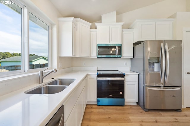 655 11th St SW, Bandon, OR 97411 - kitchen with appliances with stainless steel finishes, a sink, white cabinetry, and light countertops