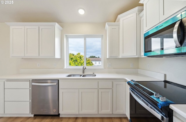 655 11th St SW, Bandon, OR 97411 - kitchen featuring stainless steel appliances, a sink, white cabinets, light countertops, and recessed lighting