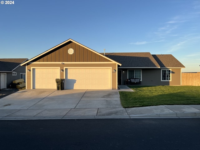 ranch-style home featuring a garage and a front lawn