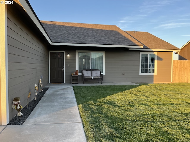 view of exterior entry with a lawn, a patio, and an outdoor hangout area