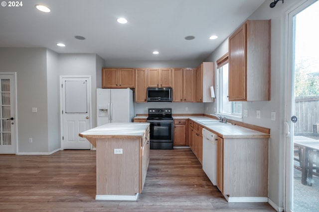 kitchen featuring a healthy amount of sunlight, sink, white appliances, and a center island