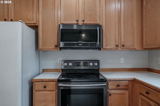 kitchen with stainless steel appliances and tile countertops