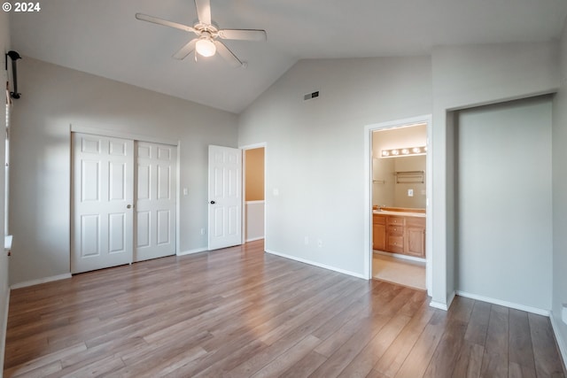 unfurnished bedroom featuring high vaulted ceiling, connected bathroom, a closet, light wood-type flooring, and ceiling fan