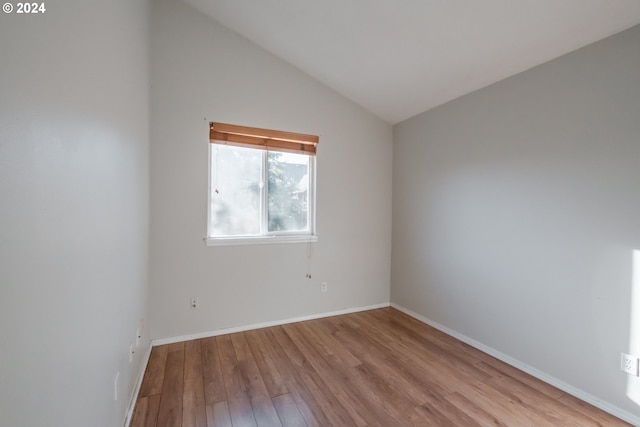 unfurnished room with vaulted ceiling and light hardwood / wood-style floors