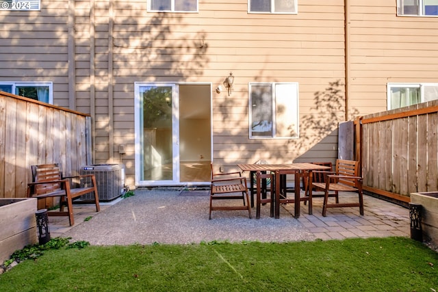 back of property featuring cooling unit, a patio area, and a yard