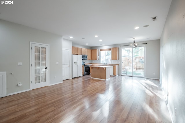 kitchen with black range with electric stovetop, a kitchen island, a chandelier, white refrigerator with ice dispenser, and light wood-type flooring