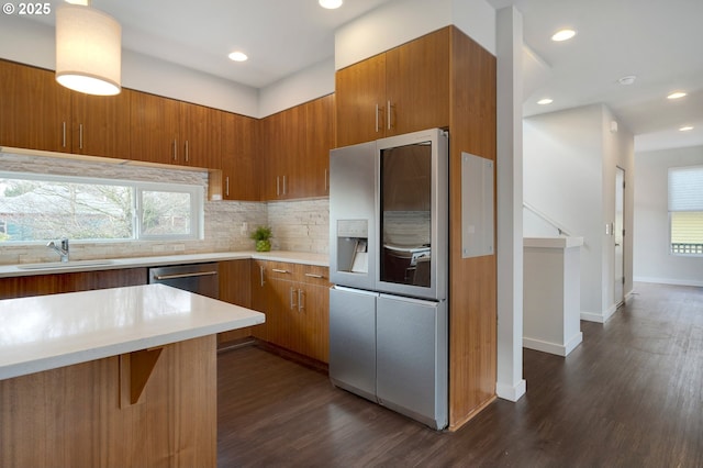 kitchen with dark hardwood / wood-style floors, stainless steel fridge with ice dispenser, tasteful backsplash, a breakfast bar area, and sink