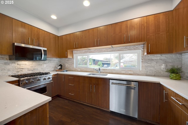 kitchen with tasteful backsplash, appliances with stainless steel finishes, dark hardwood / wood-style flooring, and sink