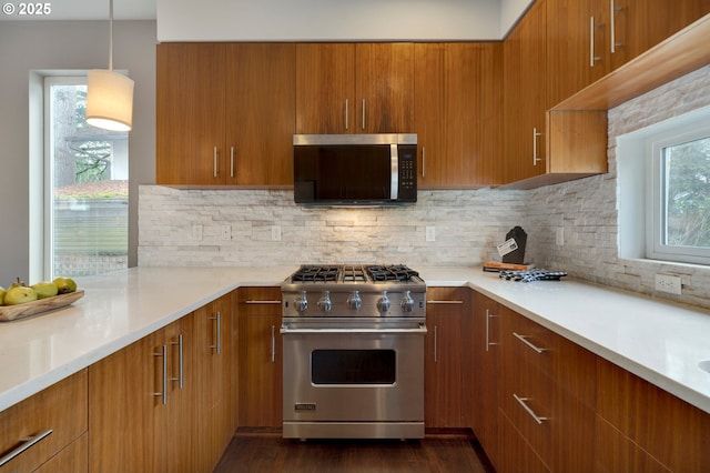 kitchen featuring appliances with stainless steel finishes, hanging light fixtures, and backsplash