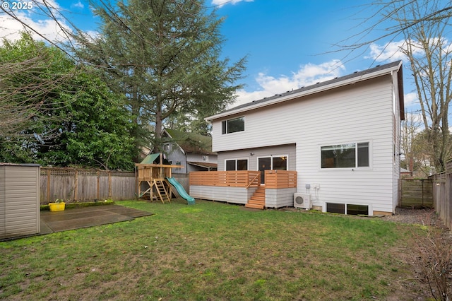 back of property with a wooden deck, ac unit, a playground, and a lawn