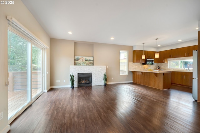 unfurnished living room with a fireplace and dark wood-type flooring