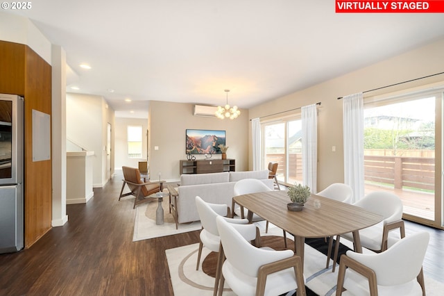 dining area featuring dark hardwood / wood-style flooring, an inviting chandelier, and a wall mounted AC