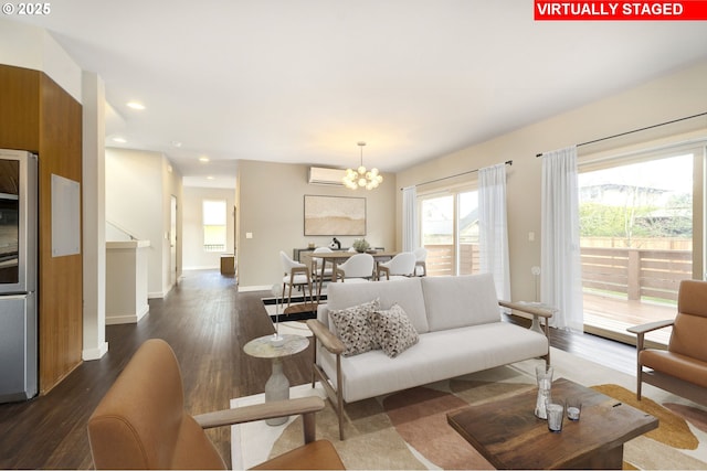 living room featuring a wall mounted air conditioner, a chandelier, and dark hardwood / wood-style floors