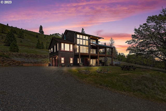 view of front of property featuring a balcony, a yard, and a garage