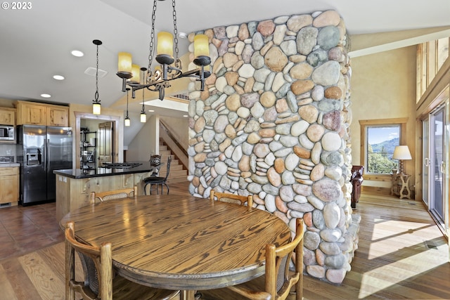 dining space featuring a notable chandelier, lofted ceiling, and hardwood / wood-style floors