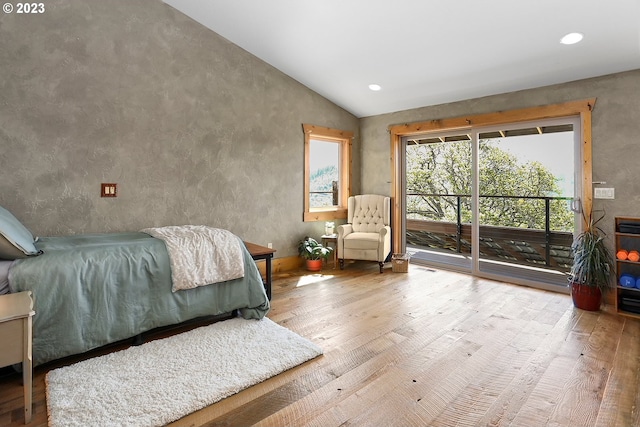 bedroom with high vaulted ceiling, light hardwood / wood-style flooring, and access to exterior