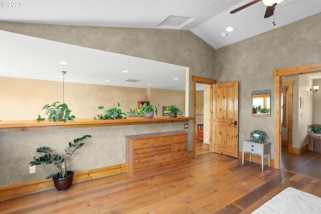 interior space with ceiling fan, dark wood-type flooring, and vaulted ceiling