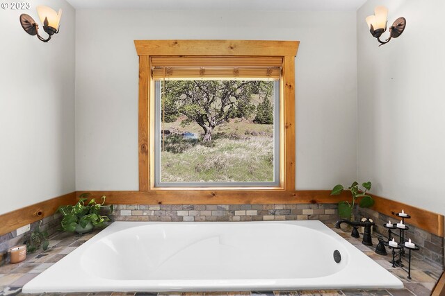 bathroom with tiled tub and plenty of natural light