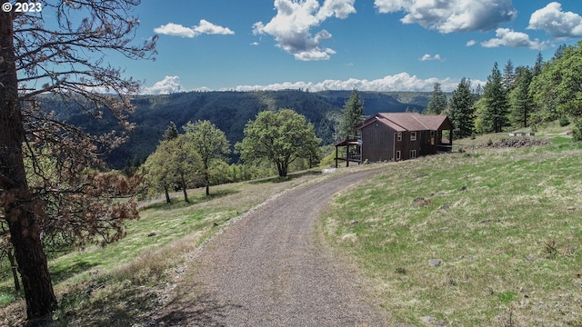 view of road with a rural view and a mountain view