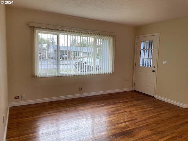 interior space featuring a textured ceiling and dark hardwood / wood-style flooring