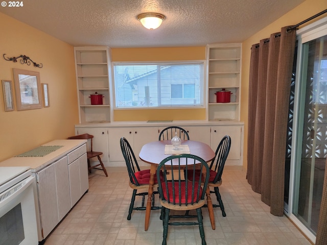 tiled dining space featuring a textured ceiling