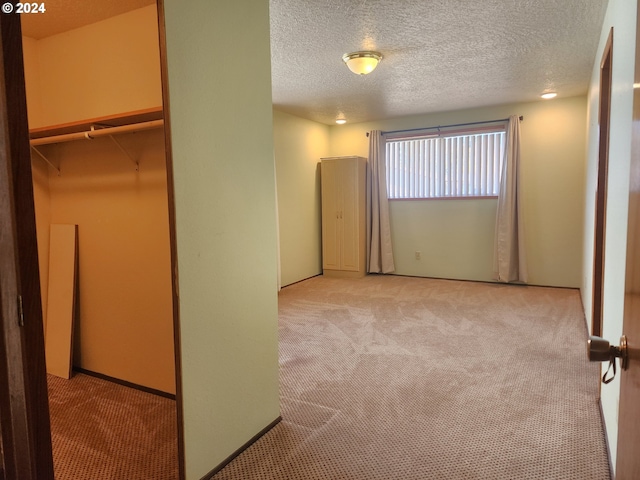 unfurnished bedroom with a closet, light carpet, and a textured ceiling