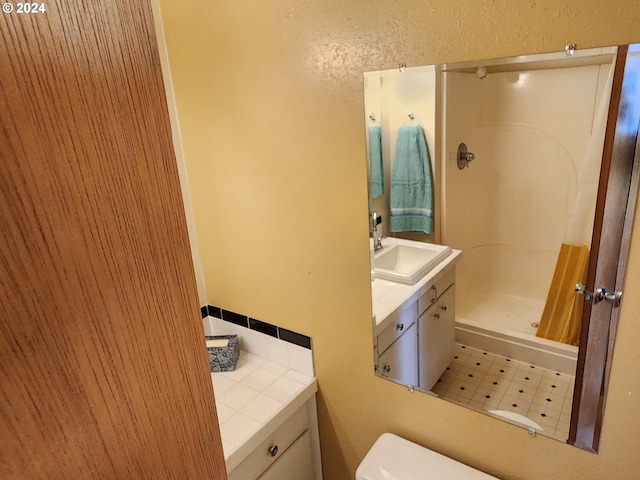 bathroom with walk in shower, tile flooring, oversized vanity, and toilet