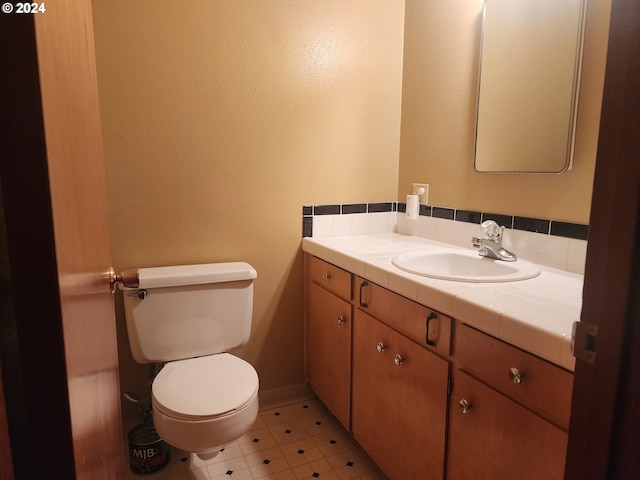 bathroom with tile floors, oversized vanity, and toilet