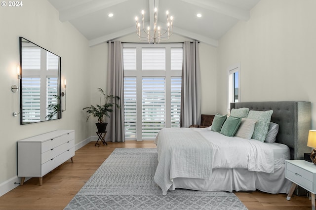 bedroom with a chandelier, beamed ceiling, and light hardwood / wood-style flooring