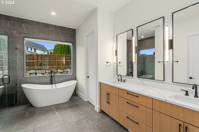 bathroom with shower with separate bathtub, vanity, and tile walls