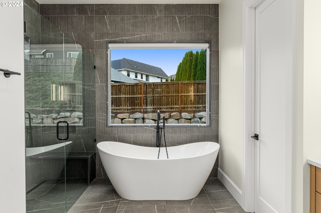 bathroom with tile patterned floors, vanity, and shower with separate bathtub