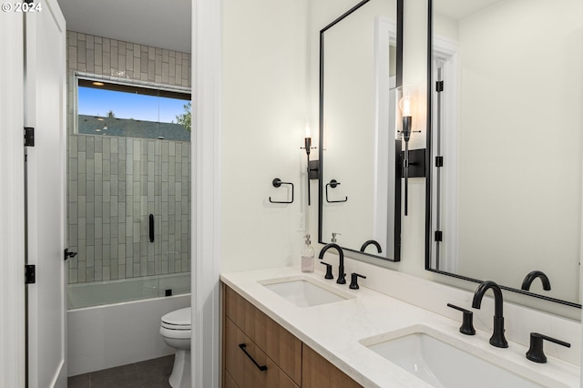 full bathroom with tile patterned flooring, tiled shower / bath combo, vanity, and toilet