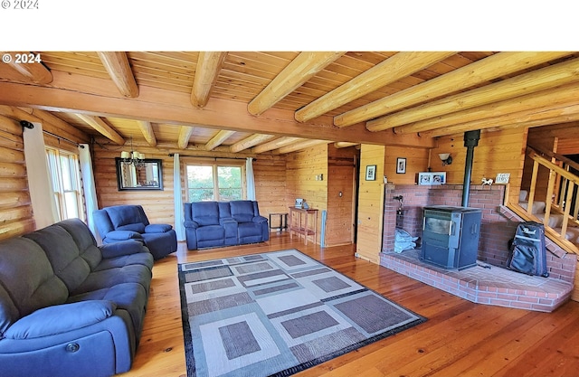 living room with beamed ceiling, wood ceiling, a wood stove, and hardwood / wood-style flooring