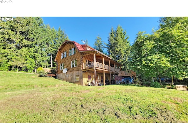 back of house with a wooden deck and a yard