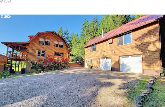 view of home's exterior with a garage, a wall mounted AC, and a deck