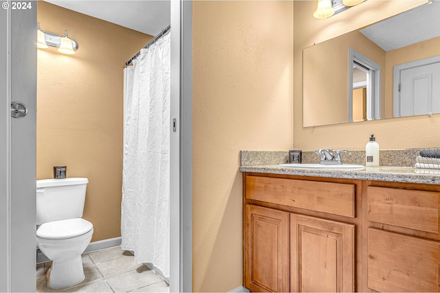 bathroom with tile patterned flooring, vanity, and toilet