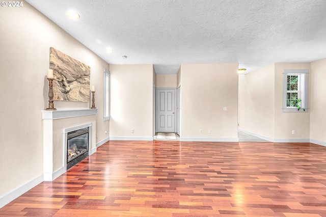 unfurnished room featuring light wood-type flooring and a textured ceiling