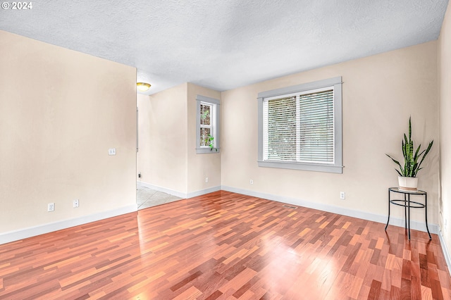 unfurnished living room with a textured ceiling and hardwood / wood-style floors