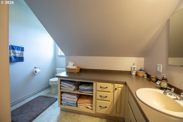 bathroom with vanity, lofted ceiling, and toilet