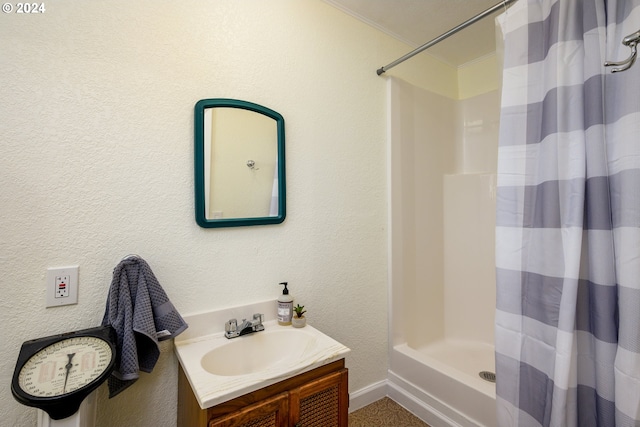 bathroom with a shower with curtain, vanity, a textured wall, ornamental molding, and baseboards
