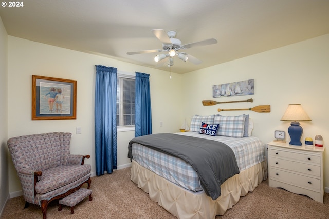 bedroom featuring light colored carpet, a ceiling fan, and baseboards