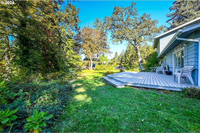 view of grassy yard with a deck