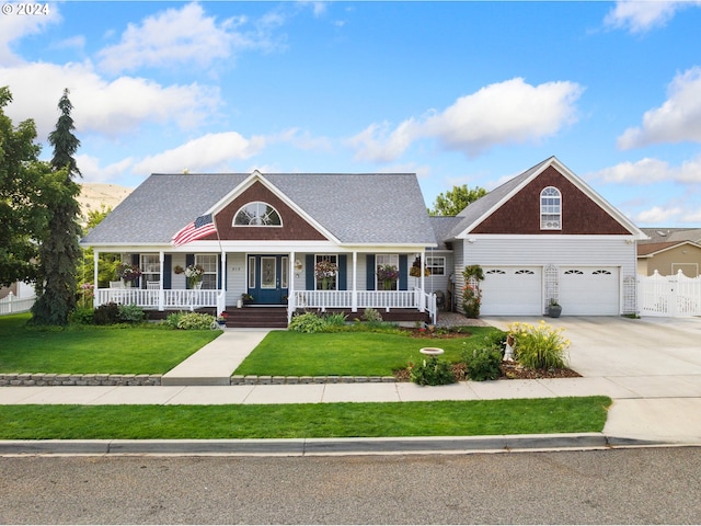 view of front facade with a garage, covered porch, and a front yard