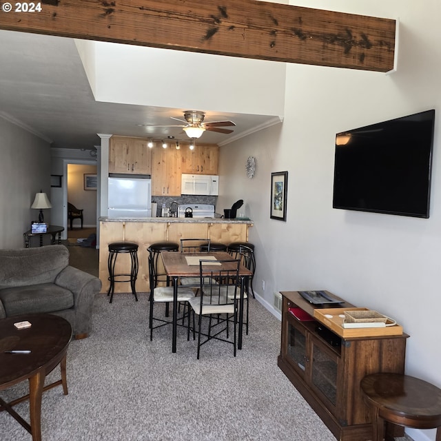 dining area featuring ceiling fan, ornamental molding, and light colored carpet