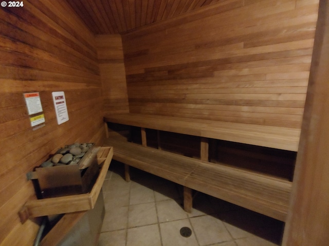 view of sauna / steam room with wood walls, wooden ceiling, and tile patterned floors