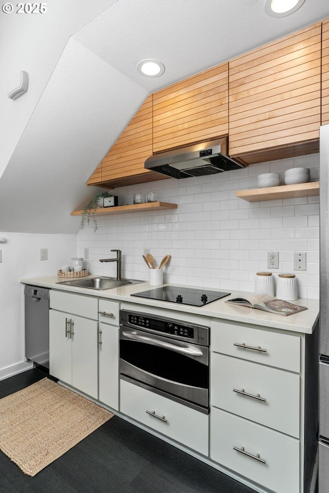 kitchen with vaulted ceiling, backsplash, appliances with stainless steel finishes, ventilation hood, and sink