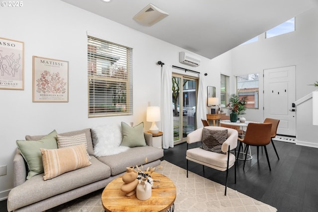 living room with a wall mounted air conditioner, vaulted ceiling, and wood-type flooring