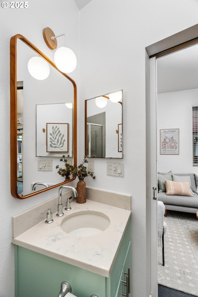 bathroom featuring an enclosed shower and vanity