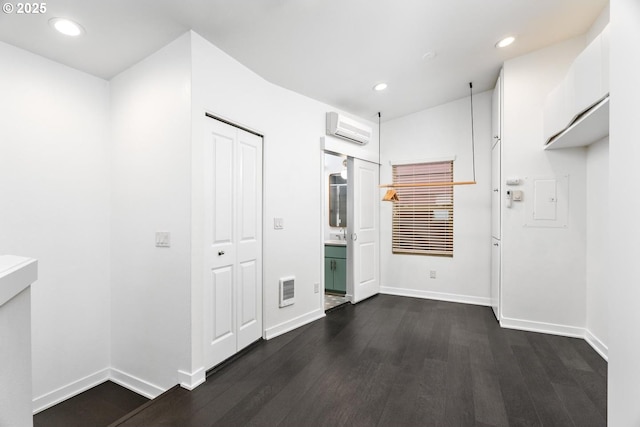 corridor with dark hardwood / wood-style flooring and a wall unit AC